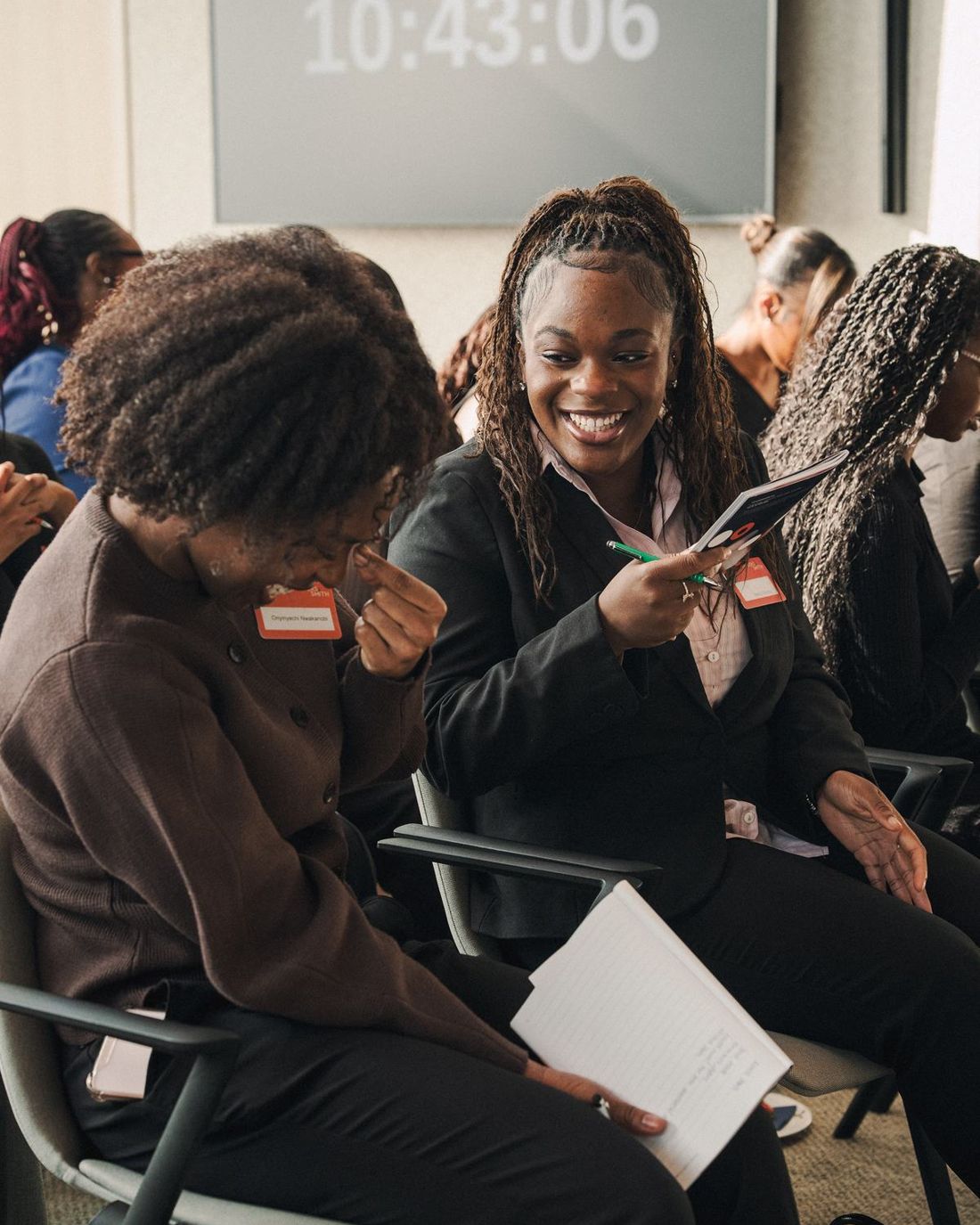 Two women laughing together at a WCAN event